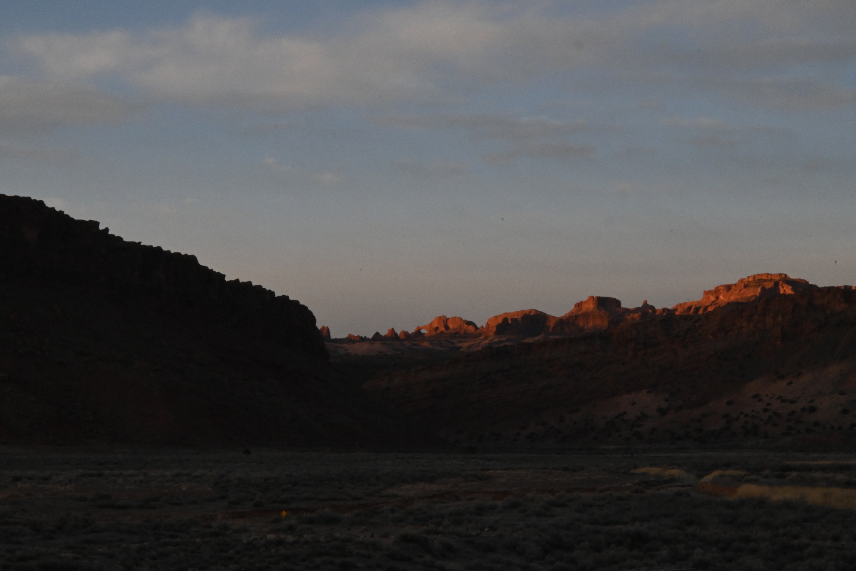 color photo of a line of red stone arches lit by a sunrise
